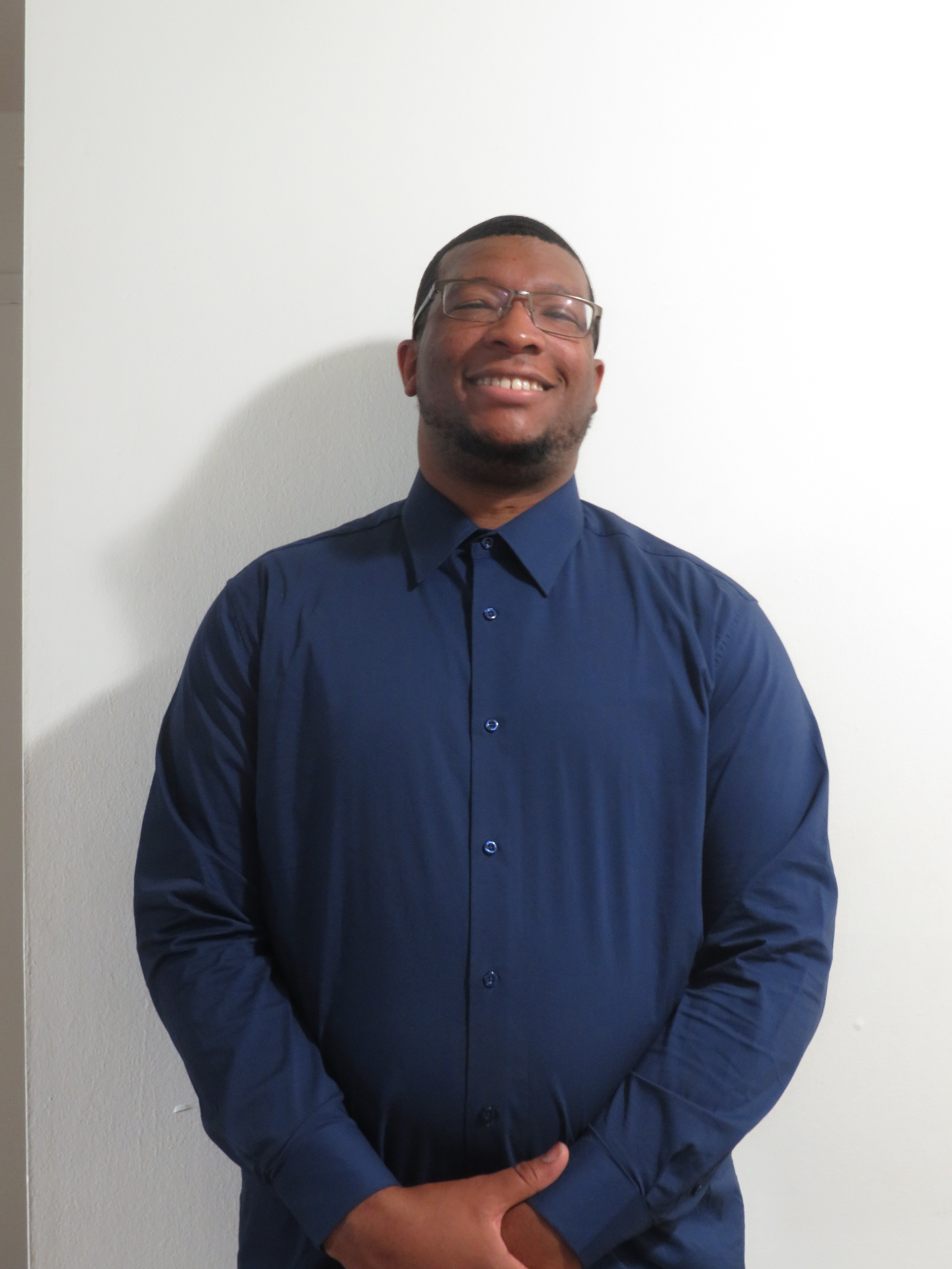Professional portrait of Valden Campbell smiling in a navy shirt.