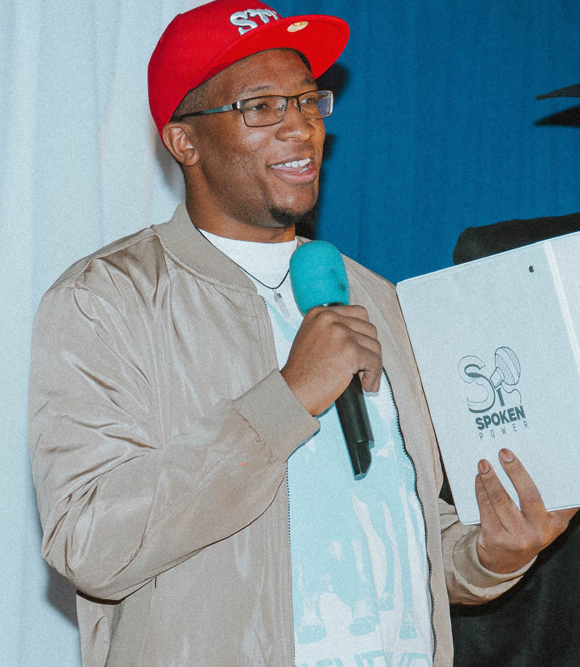 Valden Campbell at an event holding a Spoken Power binder.